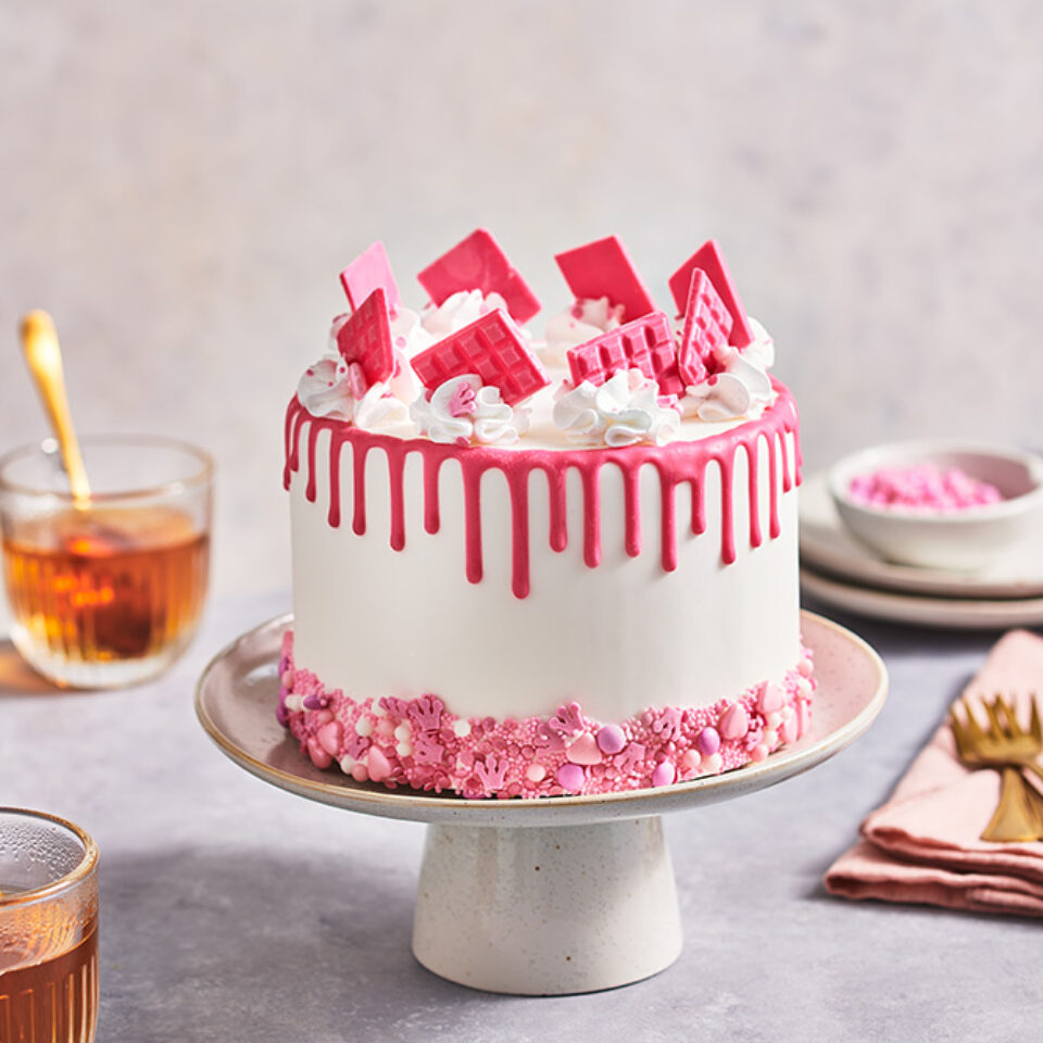 Pink drip cake with sprinkles and mini choco bars